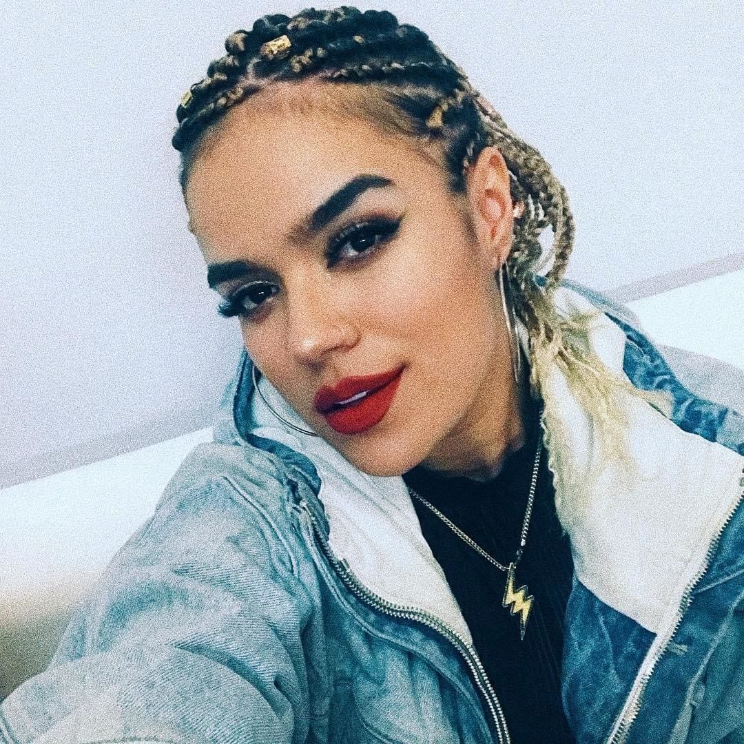 Karol G red lipstick and braids