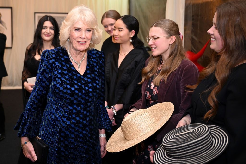 Queen Camilla engages with students and designers showcasing sustainable fashion at Highgrove House during a gala dinner.