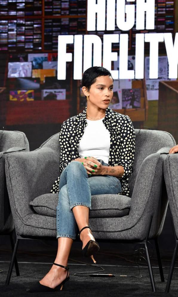 Zoe Kravitz in a polka dot blouse, white top, and jeans