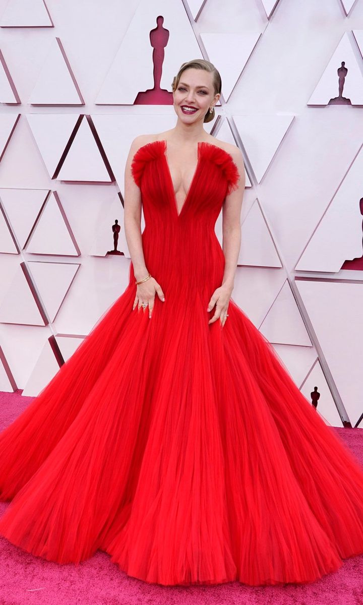 Amanda Seyfried looks red hot in a plunging red gown on the Oscars red carpet