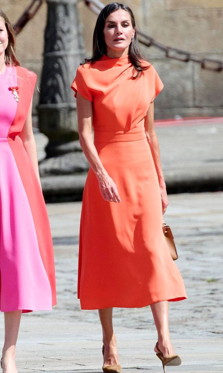 Queen Letizia stunned in a vibrant orange midi dress teamed with suede heels.