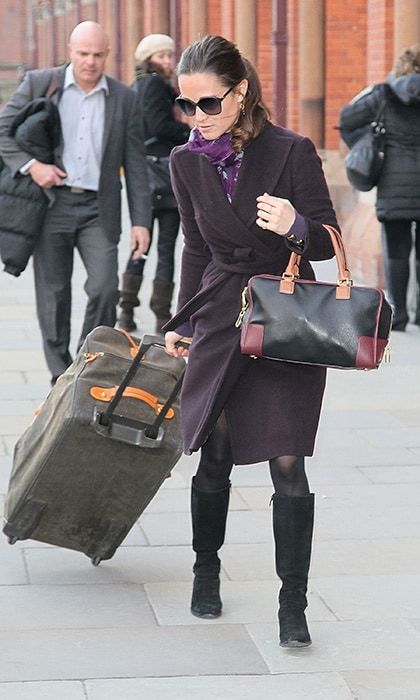 Even when toting heavy luggage, she managed to look flawless in a purple coat, matching scarf and oversized sunglasses.
<br>
Photo: Getty Images