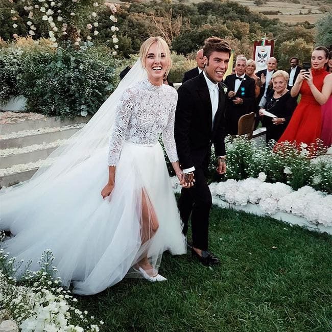 Chiara Ferragni walking with her husband, Federico Leonardo Lucia (Fedez), wearing her wedding dress designed by Dior