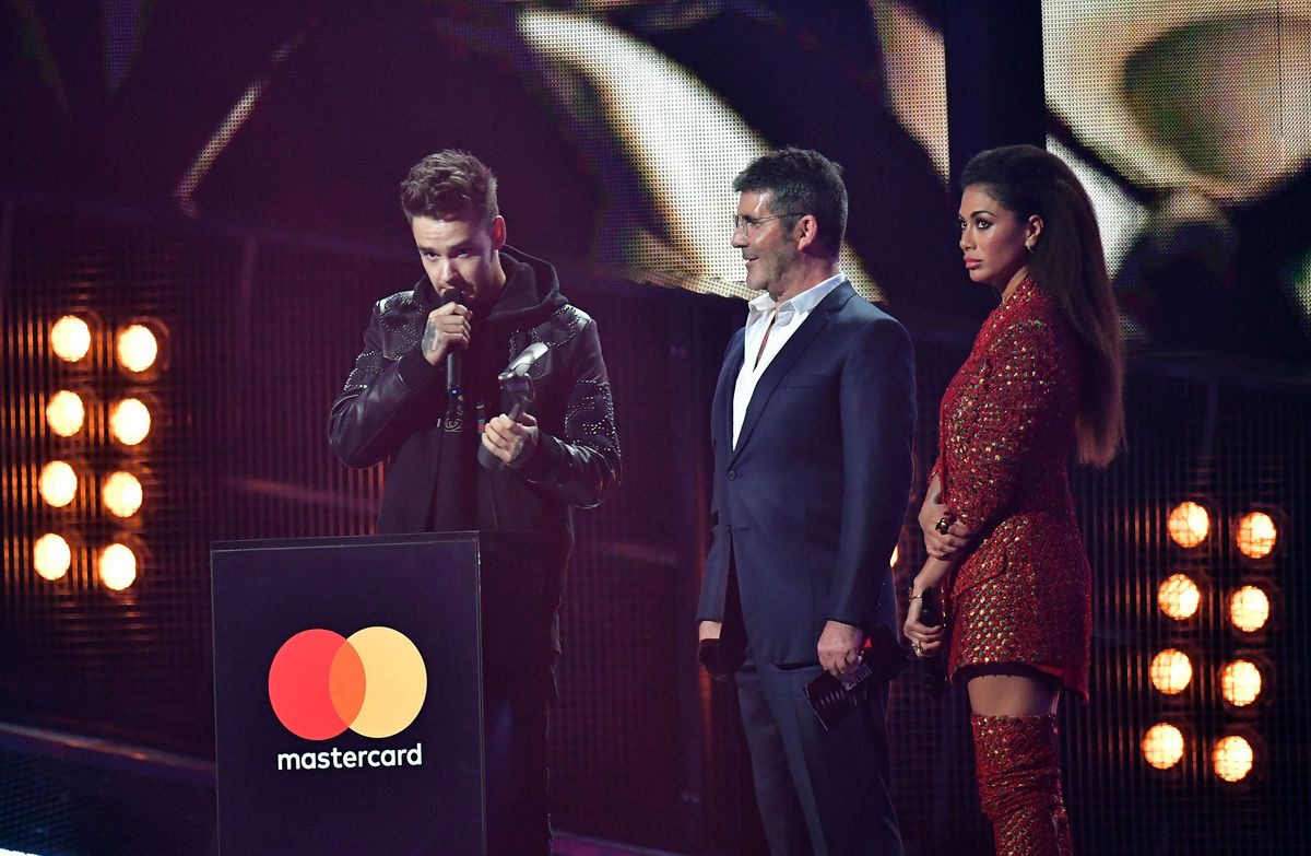 Nicole Scherzinger and Simon Cowell look on as Liam Payne collects his award for One Direction on stage at the Brit Awards at the O2 Arena, London. (Photo by Dominic Lipinski/PA Images via Getty Images)