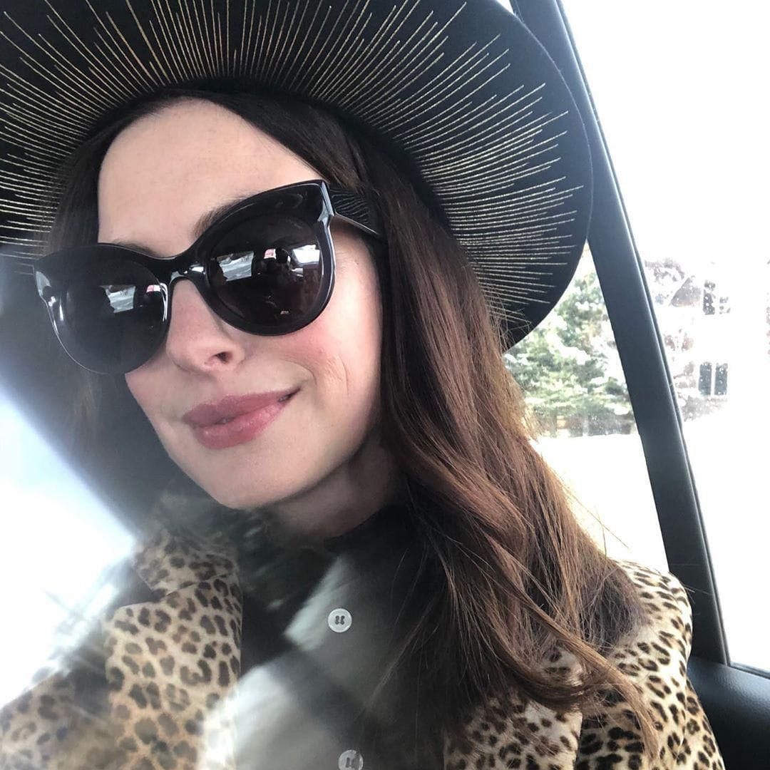 Anne Hathaway with sunglasses and a hat