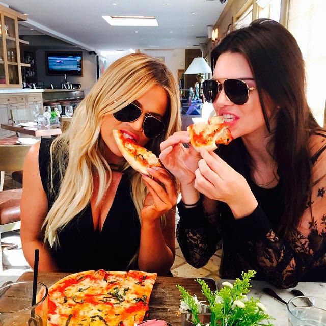 Khloe Kardashian and Kendall Jenner eating pizza