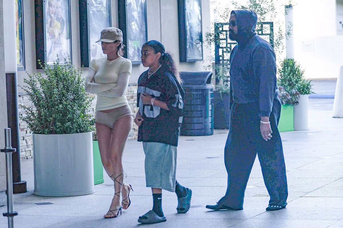 Rapper Kanye West and his wife Bianca Censori had a blast on a family outing, whisking his daughter North West away to catch the highly anticipated new 'Deadpool & Wolverine movie in Los Angeles. 

Bianca only went half-conservative in her outfit, wearing a long-sleeved shirt and nude underwear. It's been noted that Bianca has been asked to cover up her provocative outfits when around the children. 

Bianca also played up to her step-mom role as she was seen hugging her arms around North West before heading into iPic to catch the movie. The newly anticipated Marvel film 'Deadpool & Wolverine' is also rated R for mature adult scenes, making a questionable choice for their 11-year-old daughter to accompany.
