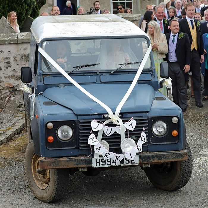 Kit took the wheel as the couple climbed into a rather rugged looking Land Rover Defender, which had been decorated with paper hearts and the words, "Just Married".
Photo: Getty Images