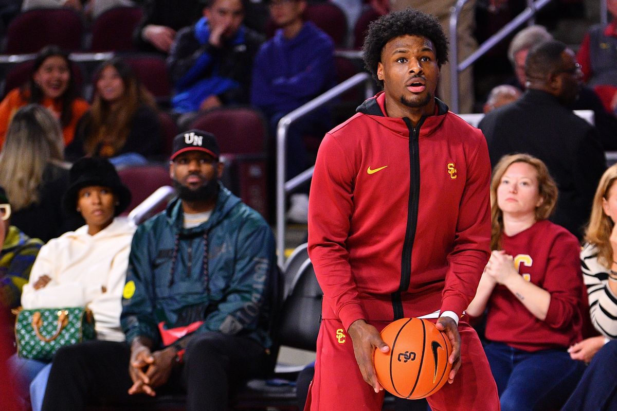 Former USC Trojans guard Bronny James (6) warms up as his parents Lebron James and Savannah James look on before the college basketball game between the Washington State Cougars and the USC Trojans on January 10, 2024 at Galen Center in Los Angeles, CA.