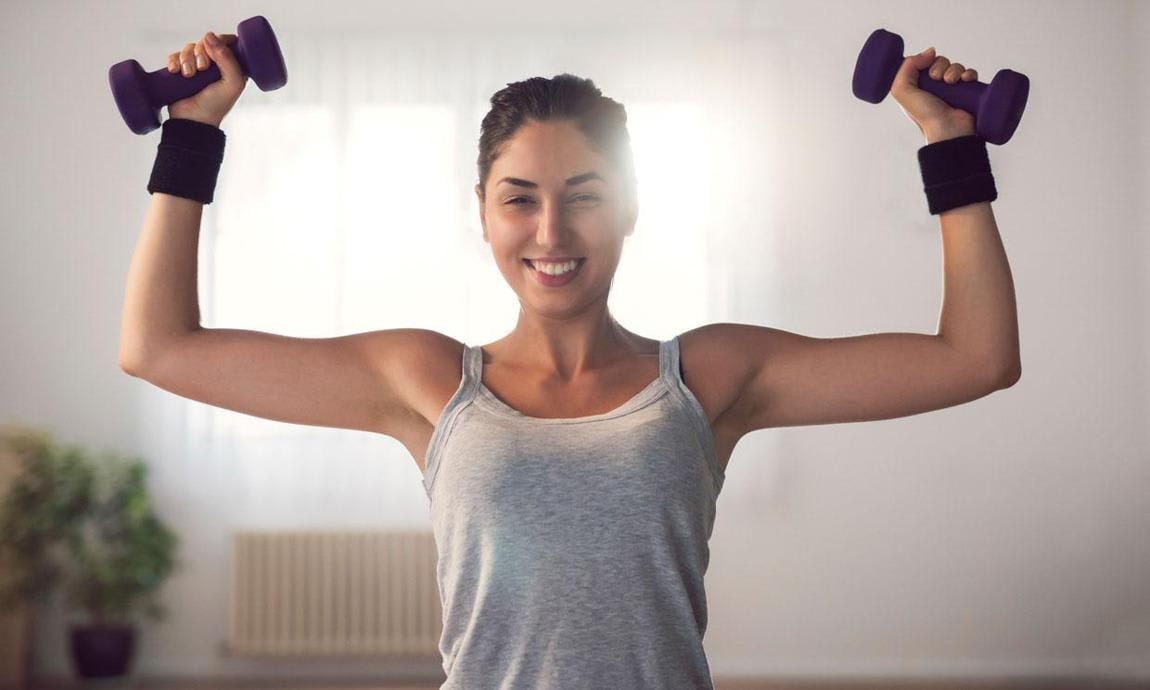 Woman lifts dumbbells