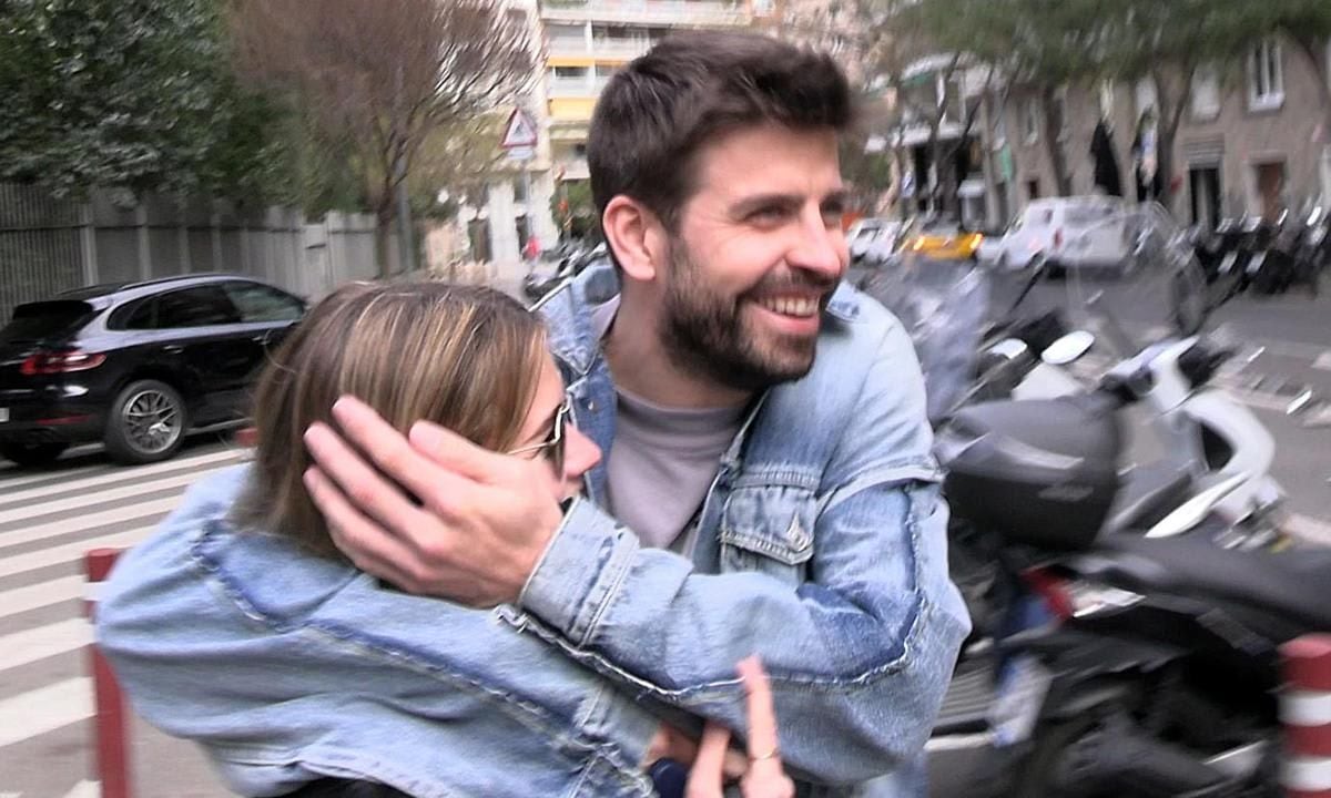 Gerard Pique and Clara Chia laugh out loud after she hits herself with an advertising sign trying to hide from a paparazzi