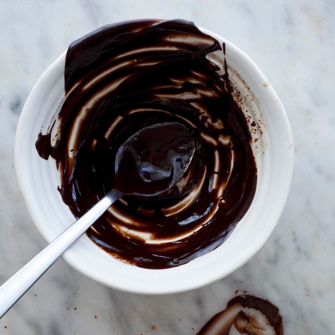 Melted dark chocolate mixing bowl spoon