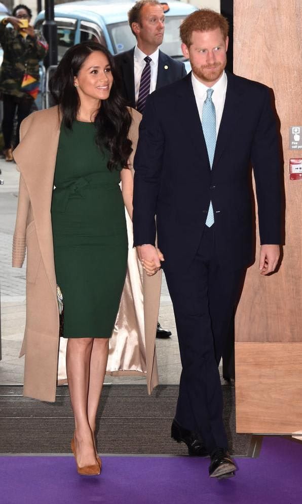 Meghan Markle in a green dress and camel coat while Harry wears a dark suit and light blue tie