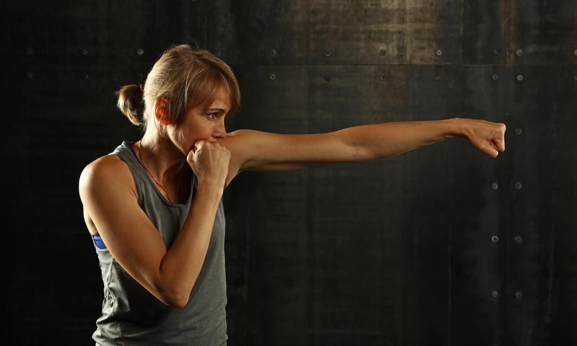 Woman throwing a cross punchn