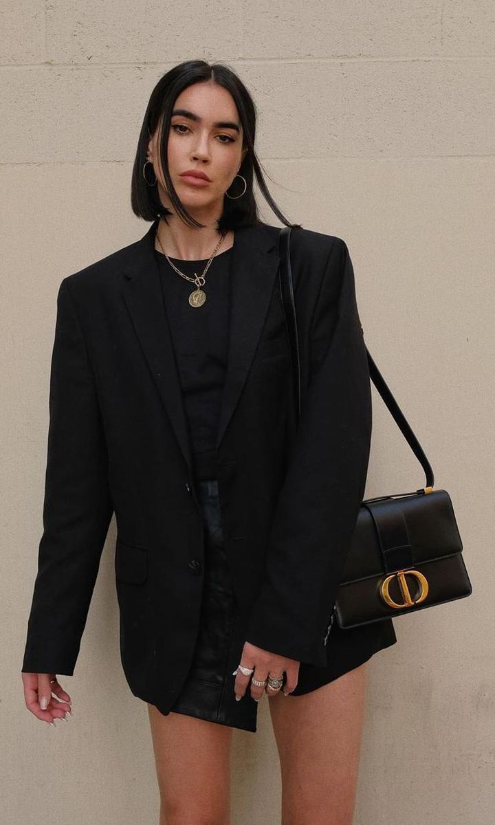 Britanny Xavier with a golden logo, black shoulder bag