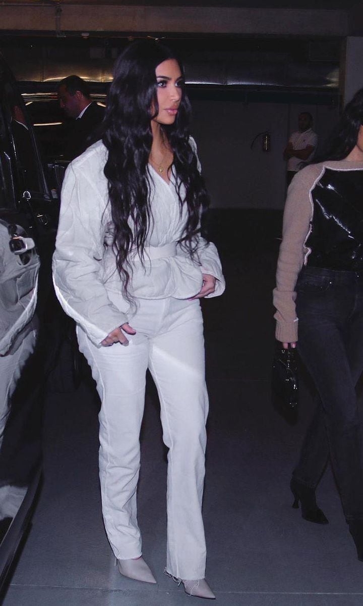 Kim Kardashian in an all-white jacket, pants, and boots