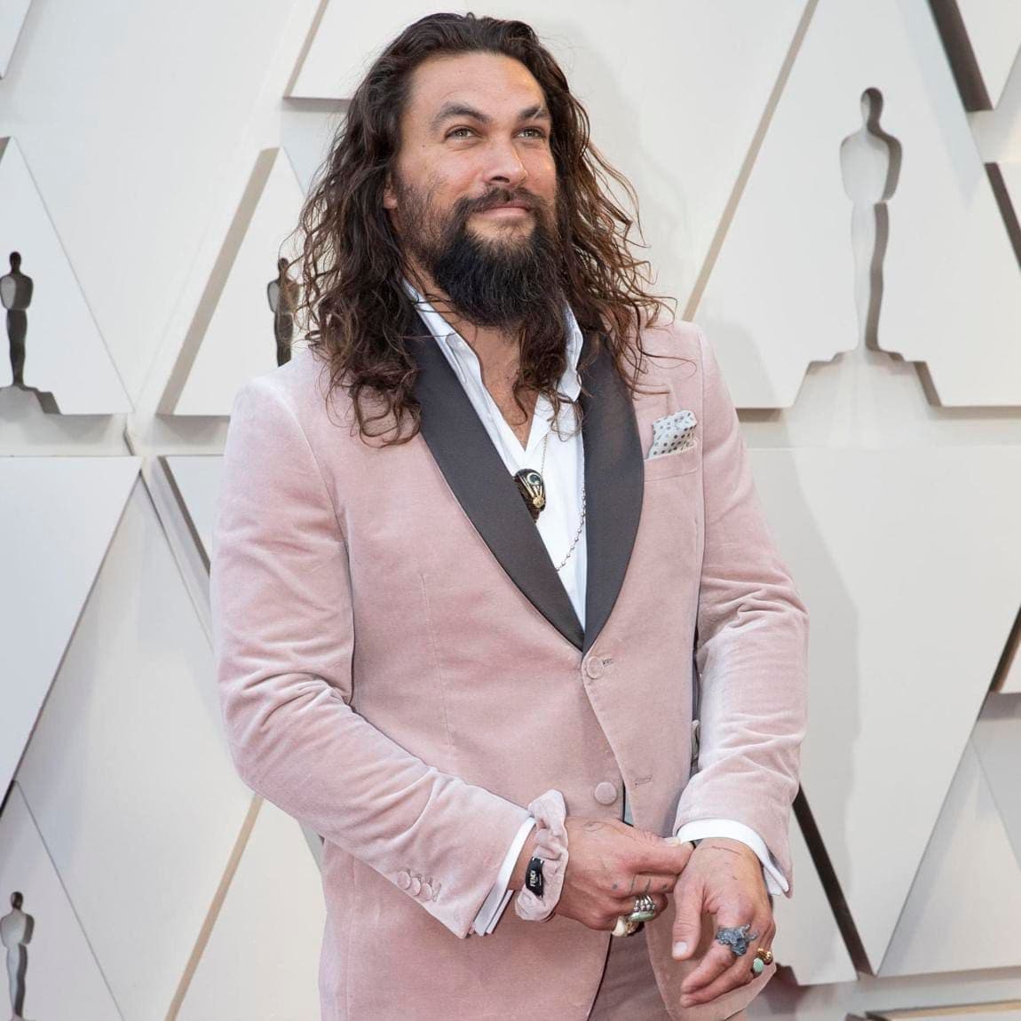 Jason Momoa con un traje rosado y scrunchie a tono de Fendi