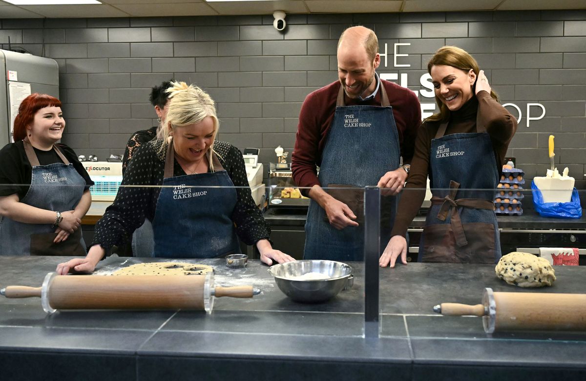 PONTYPRIDD, WALES - FEBRUARY 26: Catherine, Princess of Wales and Prince William, Prince of Wales react as they make Welsh Cakes, watched by Theresa Connor, owner of the The Welsh Cake Shop during a visit to Pontypridd Market on February 26, 2025 in Pontypridd, Wales. In December 2024, Pontypridd was one of a number of towns across Wales which was hit by severe flooding as a result of Storm Bert and Storm Darragh. The Prince and Princess met with local residents, learning about their experiences and the impact of recent events in the town. (Photo by Ben Stansall - WPA Pool/Getty Images)