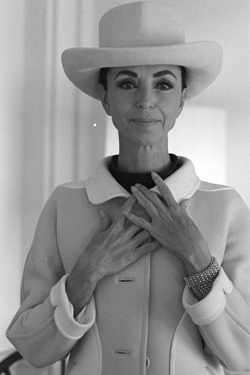 Sosialita Gloria Guinness sebelum menerima penghargaan JC Penny sebagai "reporter mode terbaik untuk majalah Amerika," mengenakan sombrero krem ​​​​dari Balenciaga dan gaun serta mantel yang dibuat khusus dari Courreges.