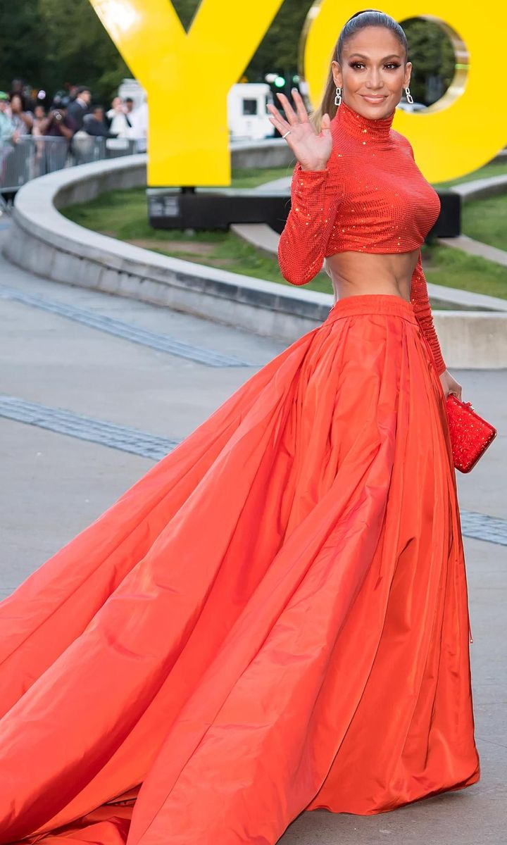 Jennifer Lopez con maxi falda y crop top anaranjado de Ralph Lauren