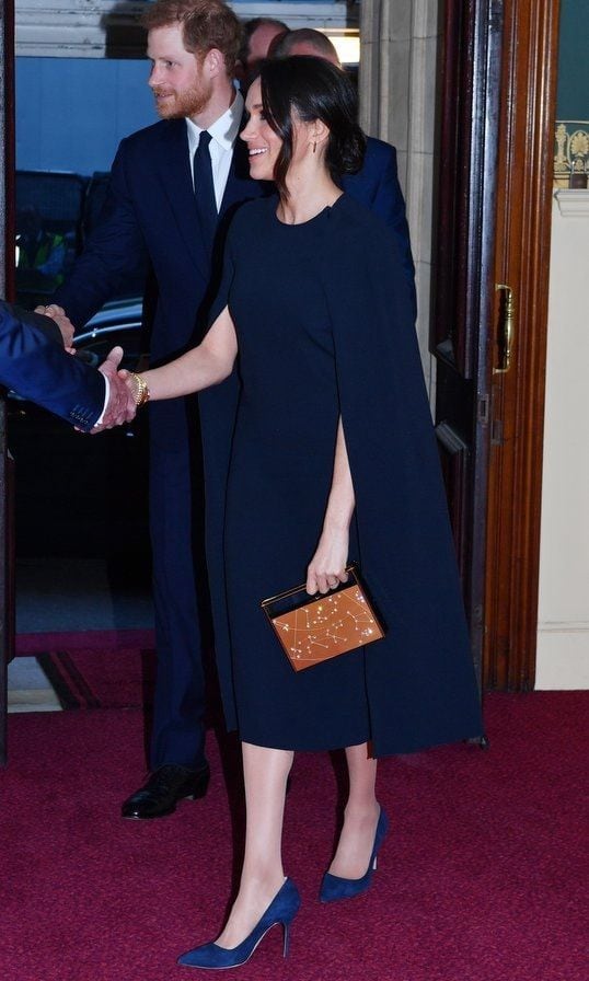 The former TV star joined Prince Harry and the British royal family for an evening out on April 21 wearing a gorgeous navy cape dress by Stella McCartney. For the event, Queen Elizabeth's 92nd birthday concert, Meghan added a personalized touch of glam by carrying one of her <a href="https://us.hellomagazine.com/fashion/12018032826440/meghan-markle-purse-top-handle-handbag/1/"><strong>signature top handle purses</strong></a>: a $1490 Naeem Khan Zodiac clutch with a design honoring her astrological sign, Leo.
Photo: Getty Images