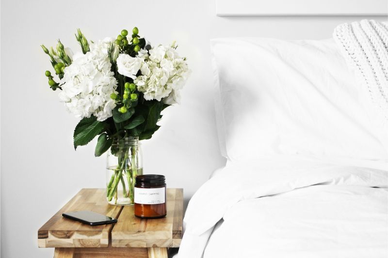 Bed with white linens and flowers