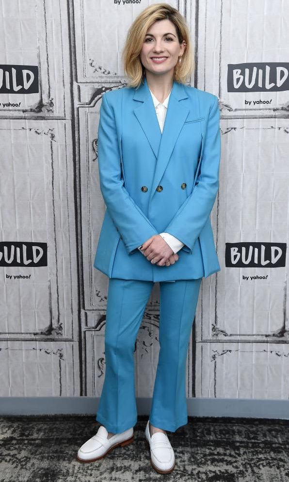Jodie Whittaker with a light blue tailored suit and white leather loafers