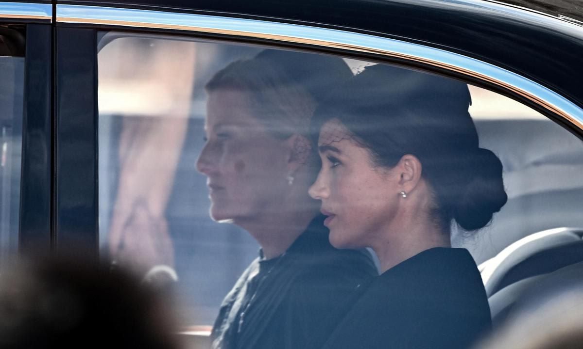 Britain's Sophie, Countess of Wessex (L) and Meghan, Duchess of Sussex are driven behind the coffin of Queen Elizabeth II, adorned with a Royal Standard and the Imperial State Crown and pulled by a Gun Carriage of The King's Troop Royal Horse Artillery, during a procession from Buckingham Palace to the Palace of Westminster, in London on September 14, 2022. - Queen Elizabeth II will lie in state in Westminster Hall inside the Palace of Westminster, from Wednesday until a few hours before her funeral on Monday, with huge queues expected to file past her coffin to pay their respects. (Photo by Marco BERTORELLO / AFP) (Photo by MARCO BERTORELLO/AFP via Getty Images)