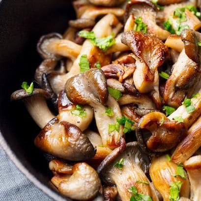 Mushrooms with fresh herbs in a black cast iron pan