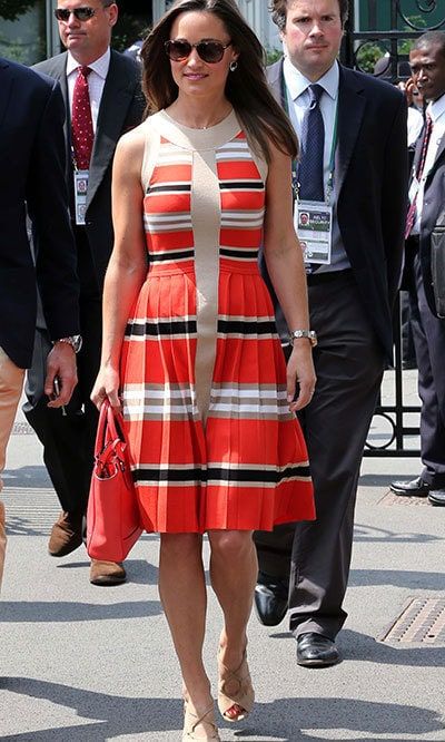 Effortlessly chic in an orange, tan and navy sundress with nude strappy sandals.
<br>
Photo: Getty Images
