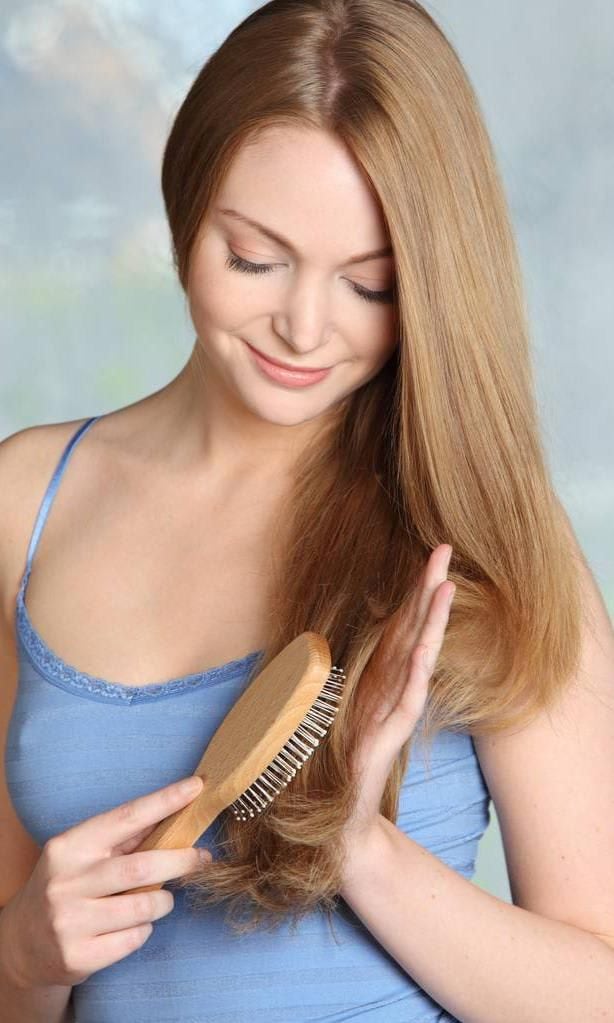 Woman carefully brushing her hair