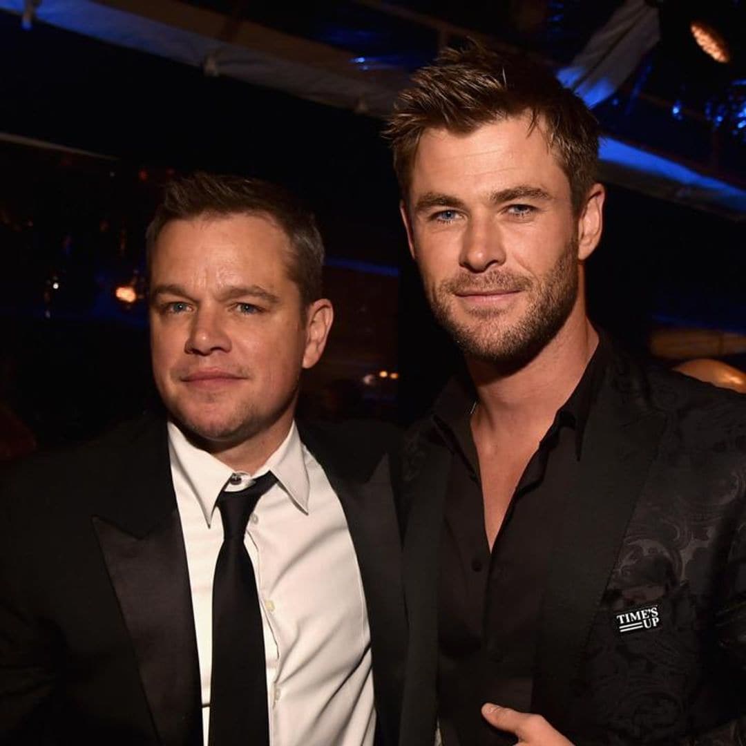 Matt Damon gets a tattoo while Chris Hemsworth holds his hand