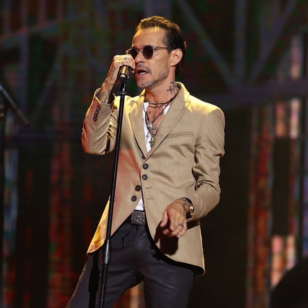 Marc Anthony helps a fan pop the question on stage during concert