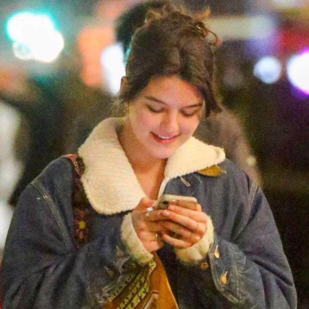 Suri Cruise can’t stop smiling while texting in NYC with a fashionable outfit