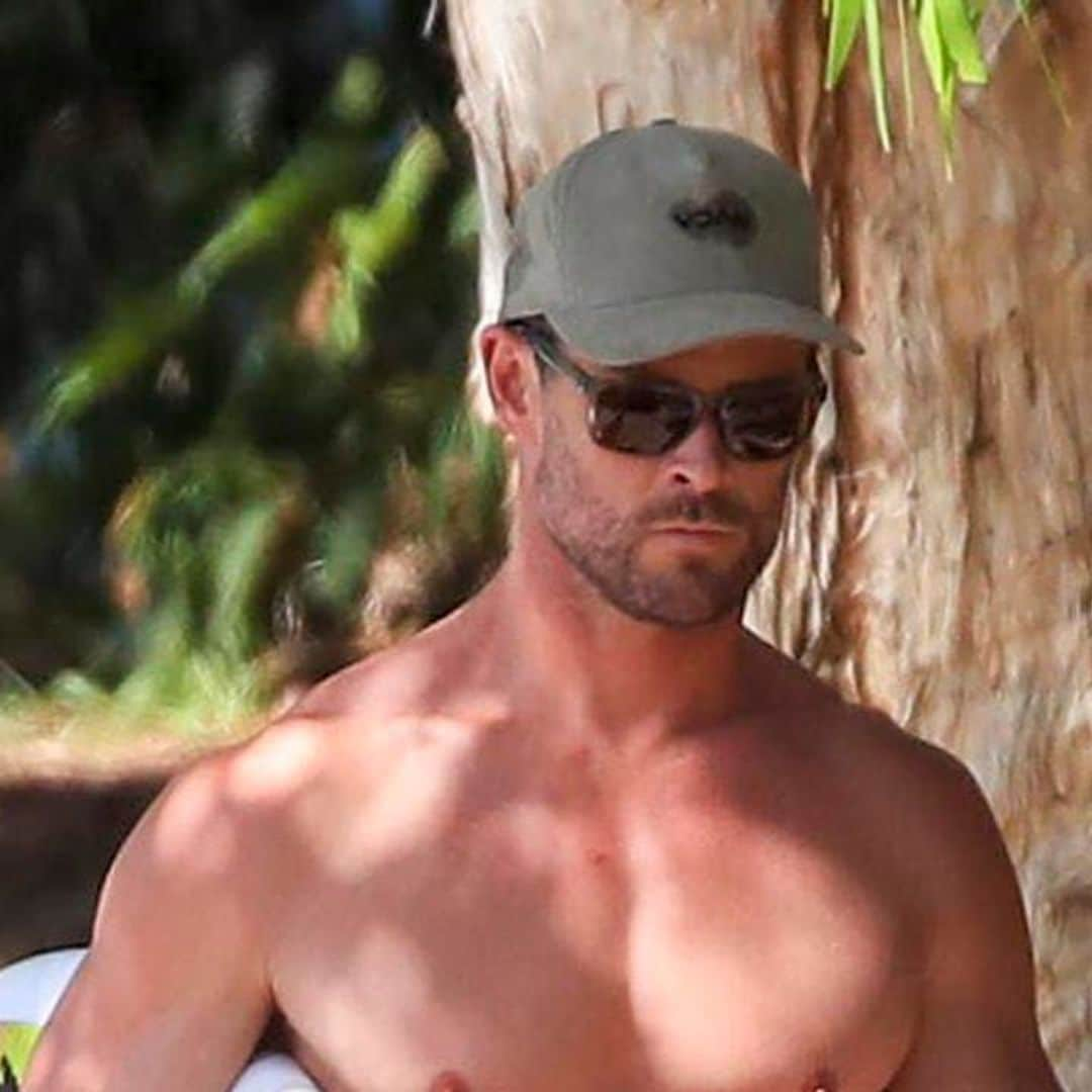 Chris Hemsworth flaunts his muscular physique while surfing at a Byron Bay beach