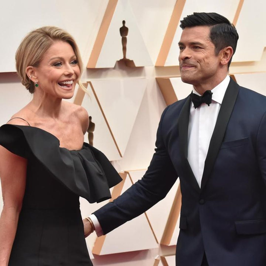 Kelly Ripa and Mark Consuelos explain how they can hold hands despite their arm’s length