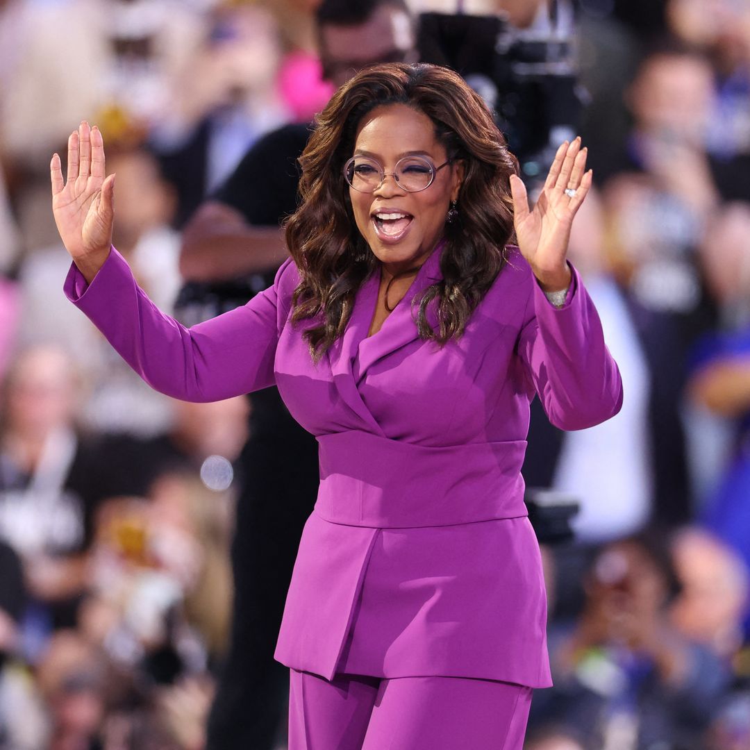 Oprah proudly displays her trim waist and well-toned physique in a purple top