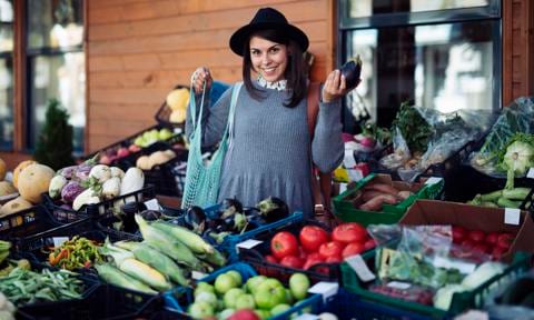 Smiling young woman shopping vegetables.